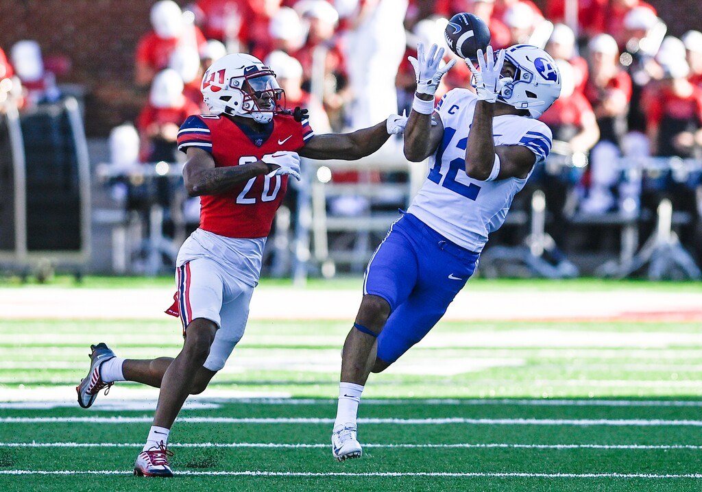(Paige Dingler/The News & Advance via AP) BYU's Puka Nacua, left, catches a pass as Liberty's Liberty cornerback Kobe Singleton defends during an NCAA college football game, Saturday, Oct. 22, 2022, in Lynchburg, Va.