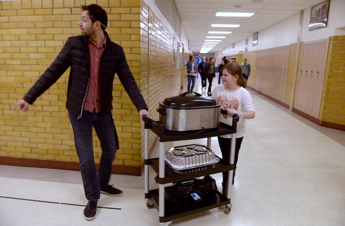 (Leah Hogsten  |  The Salt Lake Tribune) l-r Granite Park Junior High food pantry coordinator Brody Mangum and Lydia Hight, 10, cart food to the cafeteria. Sixteen members of Granite Park Junior High SchoolÕs faculty prepared and served a hot spaghetti meal to students and their families, Friday, December 22, 2017 at the school for the inaugural ÔDinner at the Park.' Roughly 90 percent of students who attend Granite Park Junior High in South Salt Lake qualify for free or reduced lunch through the federal school lunch program. Knowing the challenges faced by their students, staff members at Granite Park came up with an idea to help families through the holidays.