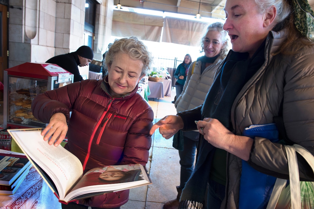 (Scott Sommerdorf   |  The Salt Lake Tribune)   Blake Spalding, co-owner of Hell's Backbone Grill in Boulder, leafs through the new cookbook, "This Immeasurable Place: Food and Farming from the Edge of Wilderness," for Katherine Stack at the Winter Market, December 9, 2017.  