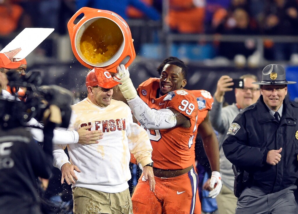 Clemson head coach Dabo Swinney, left, is dunked by Clelin Ferrell (99) after their win over Miami in the Atlantic Coast Conference championship NCAA college football game in Charlotte, N.C., Saturday, Dec. 2, 2017. (AP Photo/Mike McCarn)