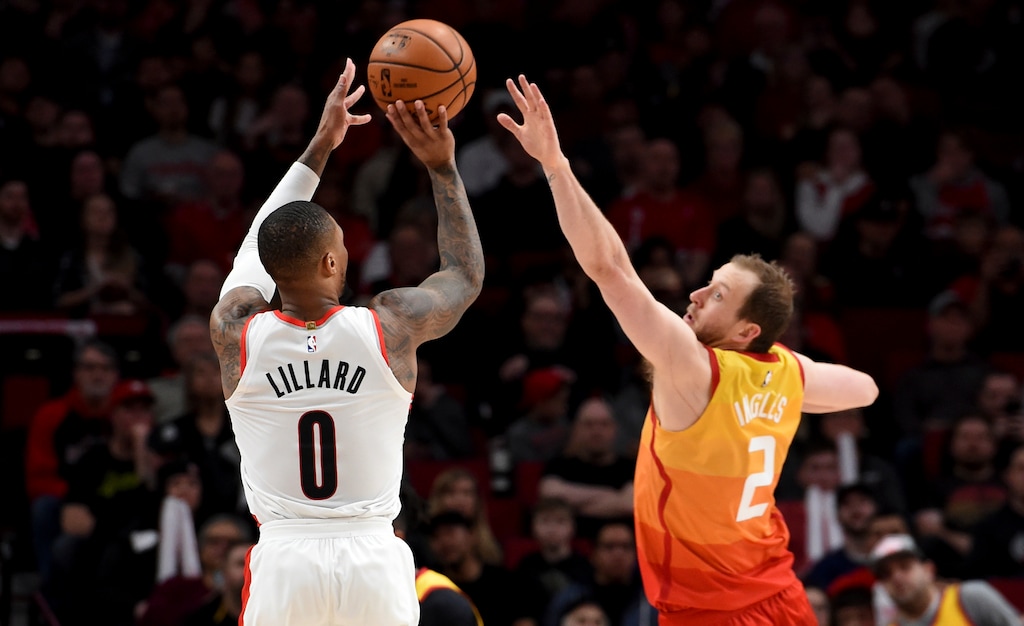 Portland Trail Blazers guard Damian Lillard, left, hits a shot over Utah Jazz guard Joe Ingles, right, during the second half of an NBA basketball game in Portland, Ore., Saturday, Feb. 1, 2020. The Blazers won 124-107. (AP Photo/Steve Dykes)
