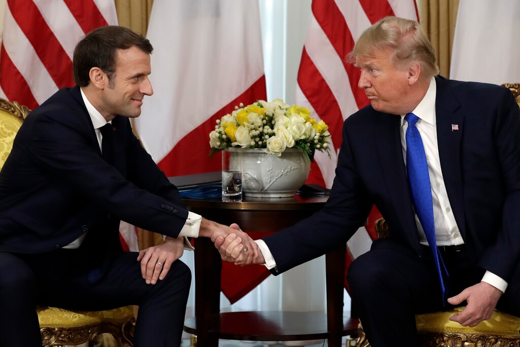 (Evan Vucci | AP) President Donald Trump shakes hands as he meets with French President Emmanuel Macron at Winfield House, Tuesday in London.
