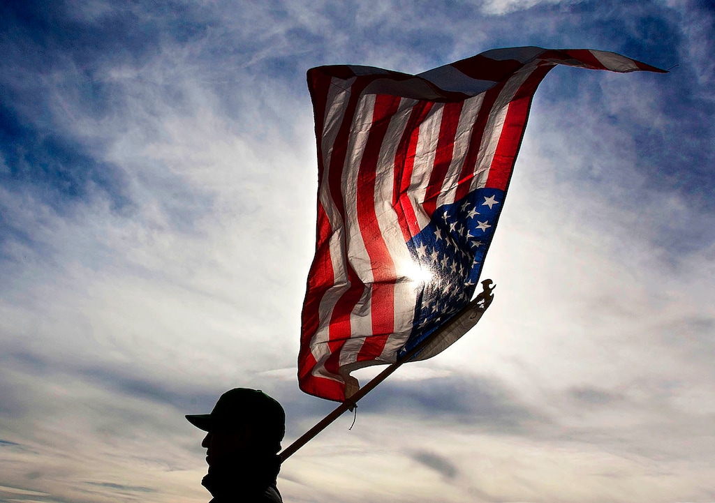 (Steve Griffin | The Salt Lake Tribune) A man holds an American Flag during a rally at the Utah State Capitol.