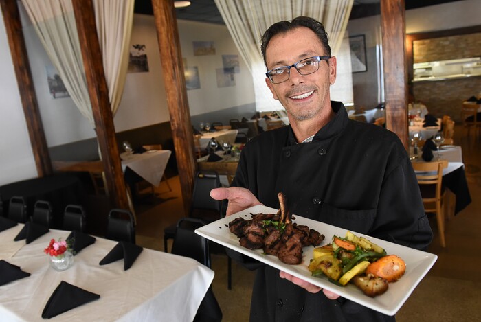 (Francisco Kjolseth | The Salt Lake Tribune) Italian restaurant chef and co-owner Francesco Montino at Per Noi Trattoria shows off the grilled rosemary lamb chops with roasted vegetables at their new location at 8657 S. Highland Drive in Sandy on Thursday, Aug. 17, 2018.