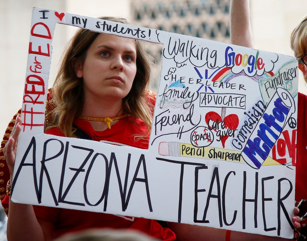 Teacher Taylor Dutro listens as protest organizers announce Arizona teachers intentions to go back to work if lawmakers pass a school funding plan, during the fourth day of the statewide teachers' strike at the Arizona Capitol Tuesday, May 1, 2018, in Phoenix. (AP Photo/Ross D. Franklin)