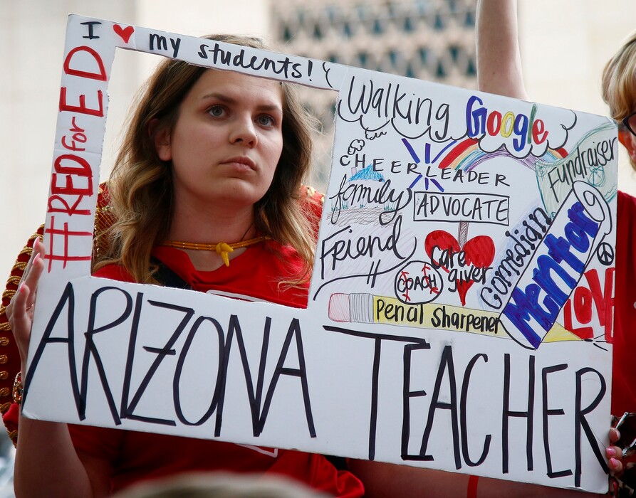 Teacher Taylor Dutro listens as protest organizers announce Arizona teachers intentions to go back to work if lawmakers pass a school funding plan, during the fourth day of the statewide teachers' strike at the Arizona Capitol Tuesday, May 1, 2018, in Phoenix. (AP Photo/Ross D. Franklin)