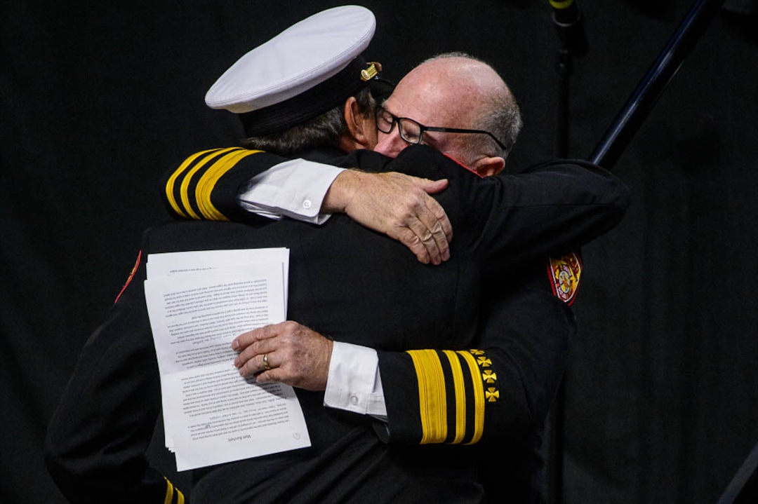 (Trent Nelson | The Salt Lake Tribune)  Dominic Burchett (brother) is embraced by District Chief Duane Woolsey at the funeral services for Battalion Chief Matthew Burchett at the Maverik Center in West Valley City, Monday Aug. 20, 2018.