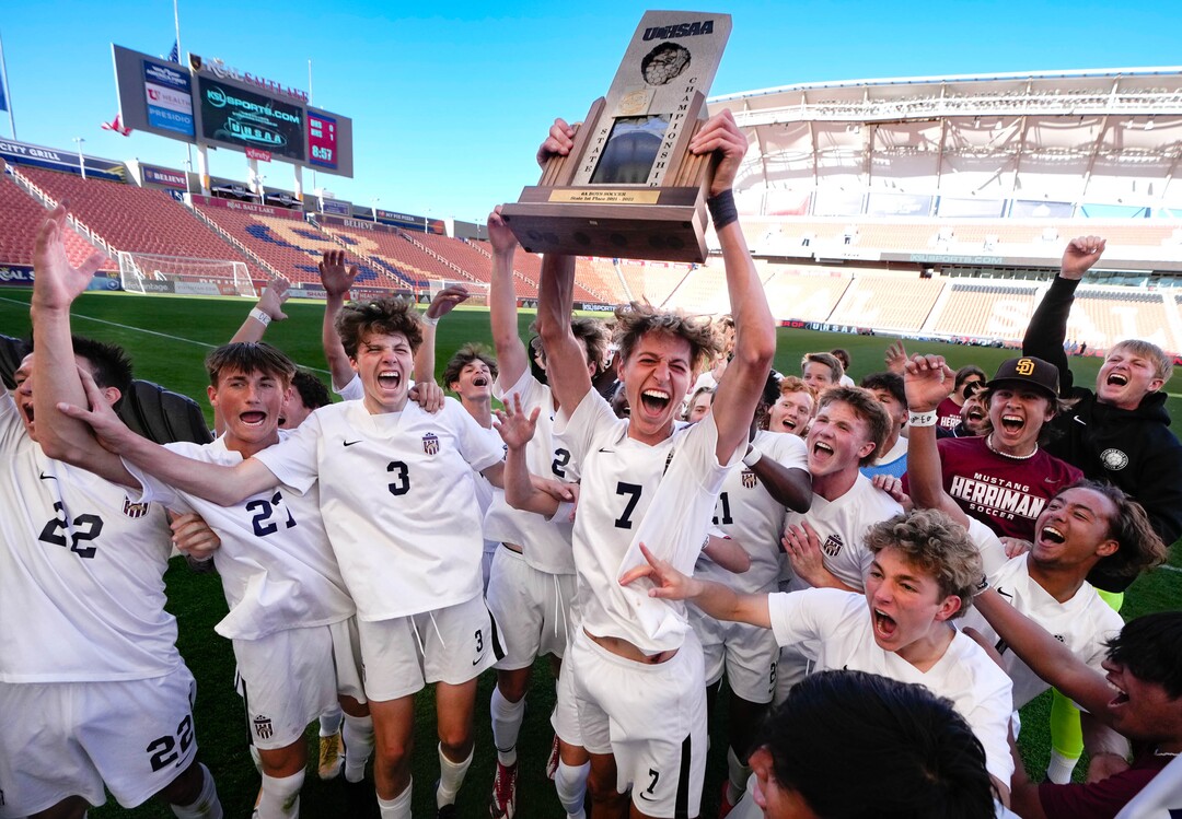 (Francisco Kjolseth | The Salt Lake Tribune) Herriman's Trevor Walk (7) hoists the championship trophy after his game winning goal came with two seconds left on the clock as the team celebrates their 6A State Soccer Championship title over Davis at Rio Tinto Stadium, Wednesday, May 25, 2022. Herriman defeated Davis 1-0.