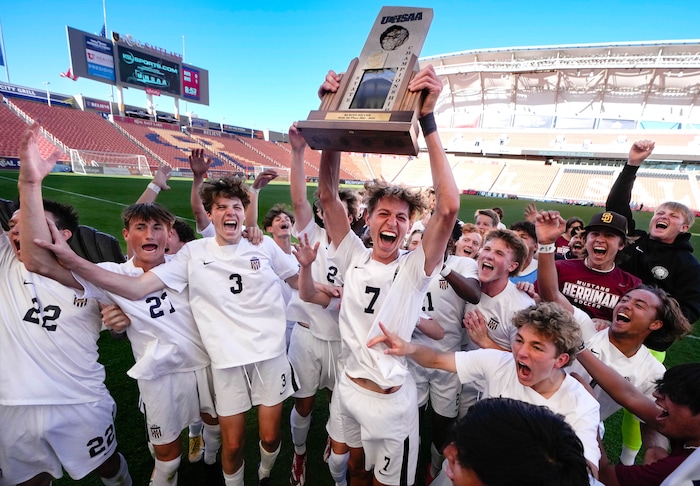 (Francisco Kjolseth | The Salt Lake Tribune) Herriman's Trevor Walk (7) hoists the championship trophy after his game winning goal came with two seconds left on the clock as the team celebrates their 6A State Soccer Championship title over Davis at Rio Tinto Stadium, Wednesday, May 25, 2022. Herriman defeated Davis 1-0.