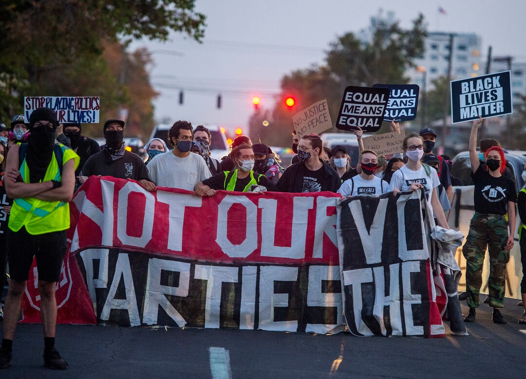 (Rick Egan  |  The Salt Lake Tribune) Protesters stop as they face a line of police in riot gear on 1300 East and 200 South, near the University of Utah where Mike Pence is debating Kamala Harris on Wednesday, Oct. 7, 2020.