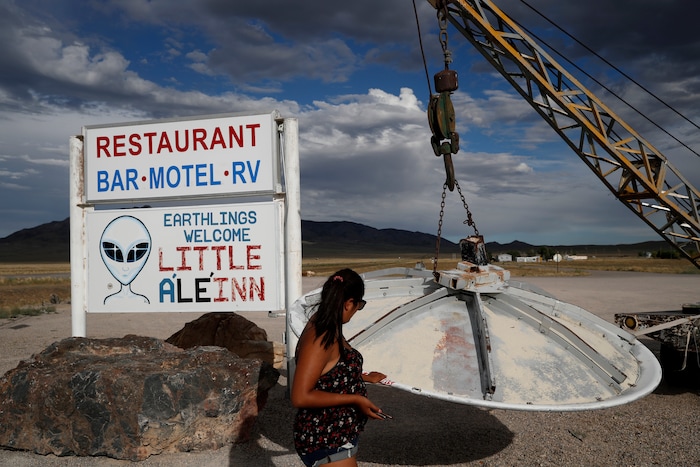 (John Locher | AP Photo) In this July 22, 2019 photo, Grace Capati looks at a UFO display outside of the Little A'Le'Inn, in Rachel, Nev., the closest town to Area 51. The U.S. Air Force has warned people against participating in an internet joke suggesting a large crowd of people "storm Area 51," the top-secret Cold War test site in the Nevada desert.