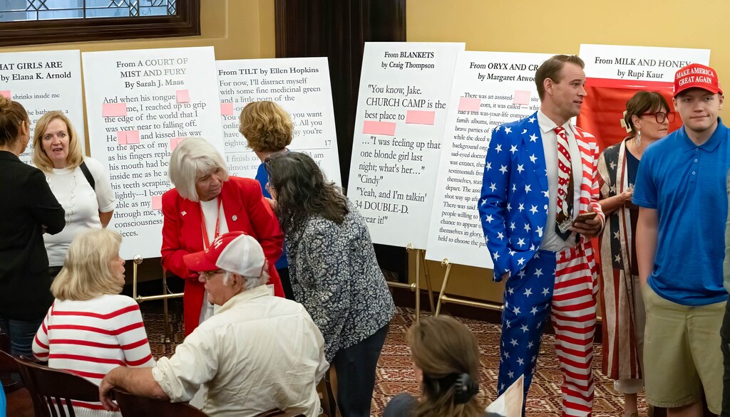 (Francisco Kjolseth  | The Salt Lake Tribune) People gather around excerpts from books removed from public schools following a news conference at the Utah Capitol to discuss why removing 13 books statewide from public schools is "a bright day" for Utah on Thursday Aug. 29, 2024.