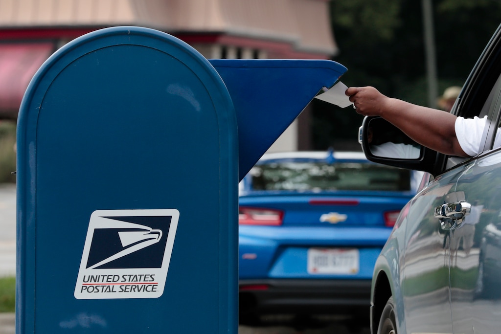 (Joshua A. Bickel | The Columbus Dispatch via AP)

A man mails a letter on Saturday in Whitehall, Ohio. Postal workers and supporters across central Ohio gathered at Post Offices across the region to protest actions by Postmaster General Louis DeJoy including the removal of sorting machines which has led to mail delivery delays in some states. Critics of these policies fear they will create delays with absentee and mail-in ballots during the upcoming general election.