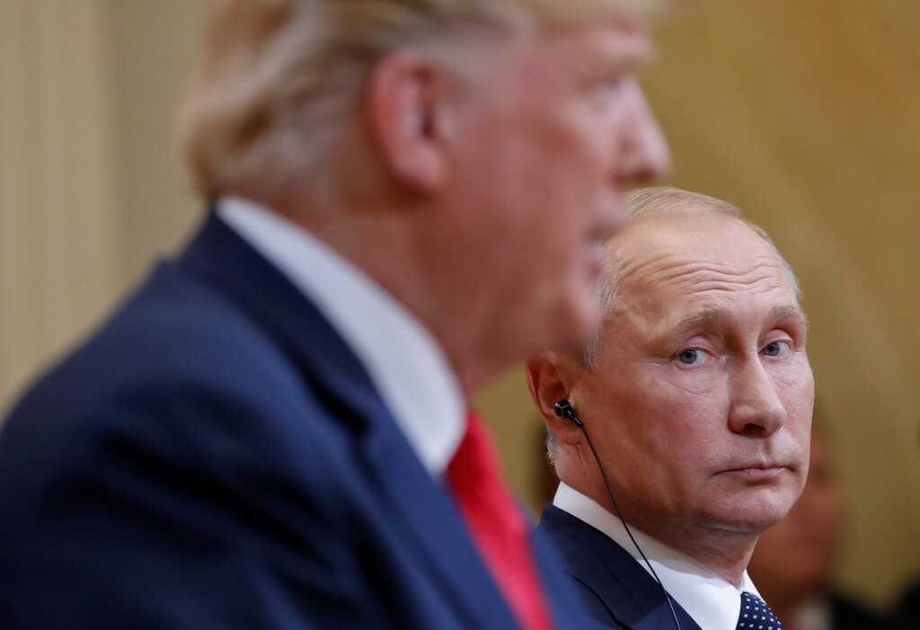 FILE - In this July 16, 2018 file photo Russian President Vladimir Putin, right, looks over towards U.S. President Donald Trump, left, as Trump speaks during their joint news conference at the Presidential Palace in Helsinki, Finland. Merkel and Putin will meet on Saturday in the German government's guesthouse Meseberg, north of Berlin, Saturday, Aug. 18, 2018. The topics will include the civil war in Syria, the conflict in Ukraine, and energy questions. (AP Photo/Pablo Martinez Monsivais, file)