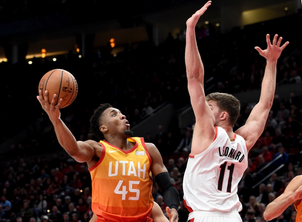 Utah Jazz guard Donovan Mitchell, left, drives to the basket as Portland Trail Blazers forward Meyers Leonard defends during the first half of an NBA basketball game in Portland, Ore., Wednesday, Jan. 30, 2019. (AP Photo/Steve Dykes)