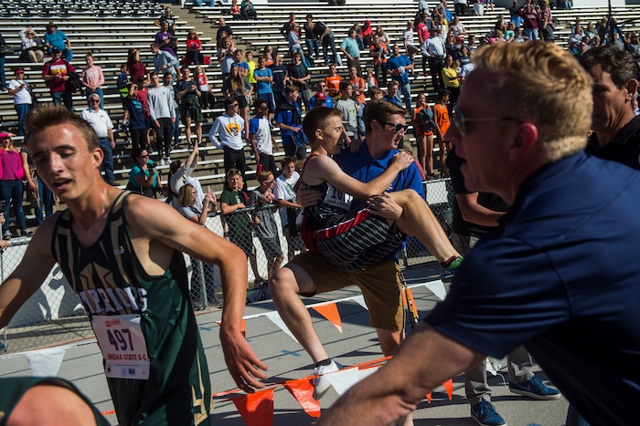 (Chris Detrick  |  The Salt Lake Tribune)  Hurricane junior Tim Amodt is carried off of the track after the 4A boy's state cross-country meet at Sugar House Park and Highland High School Wednesday, October 18, 2017. 