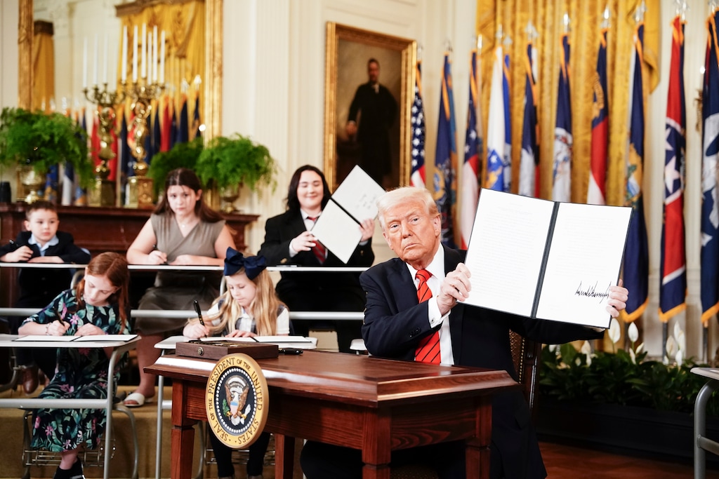 (Haiyun Jiang | The New York Times) President Donald Trump signs an executive order that would diminish the Department of Education in East Room of the White House in Washington, on Thursday, March 20, 2025. 