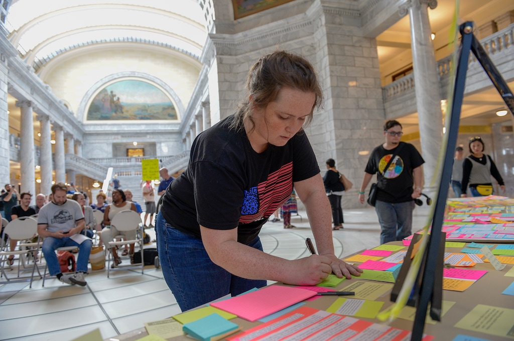 (Leah Hogsten  |  Tribune file photo) Madalena McNeil writes a note in favor of full Medicaid expansion. That expansion went into effect in January 2020.