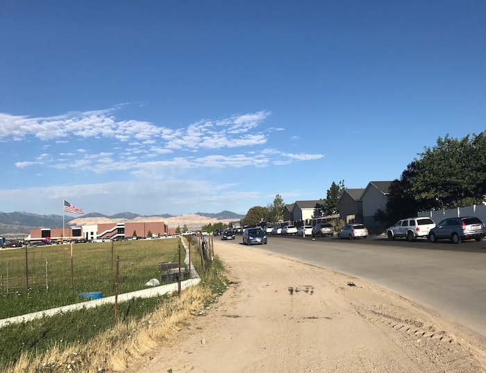 (Benjamin Wood | The Salt Lake Tribune)   Faculty members with American Preparatory Academy in Draper helped direct traffic as families arrived Monday for the first day of the 2017-2018 school year.