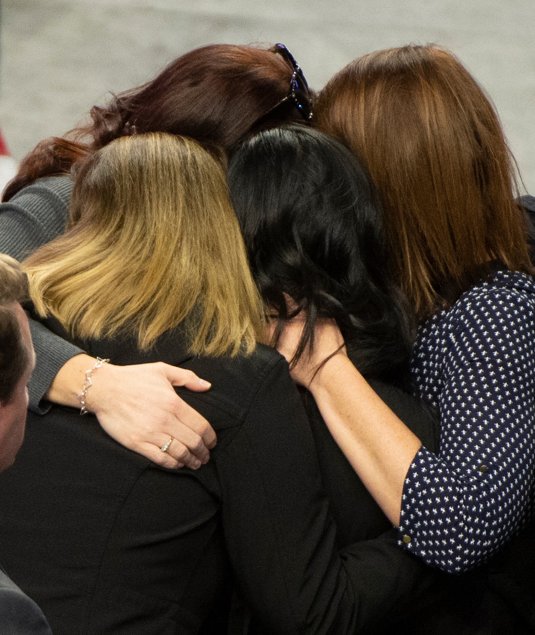 (Rick Egan  |  The Salt Lake Tribune)     Elizabeth Romrell, wife of South Salt Lake police officer, David Romrell is hugged by her loved ones, before the funeral at the Maverik Center, in West Valley City, Wednesday, Dec. 5, 2018.