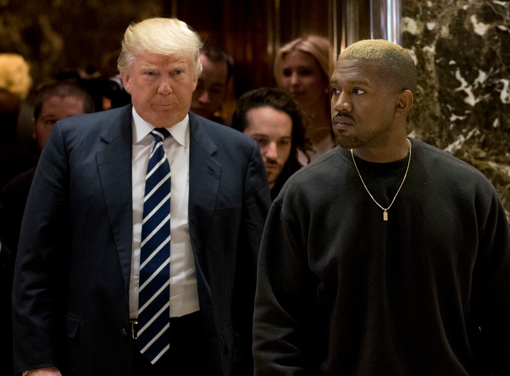 Kanye West and President-elect Donald Trump arrive to the lobby of Trump Tower in New York, Tuesday, Dec. 13, 2016. (AP Photo/Seth Wenig)