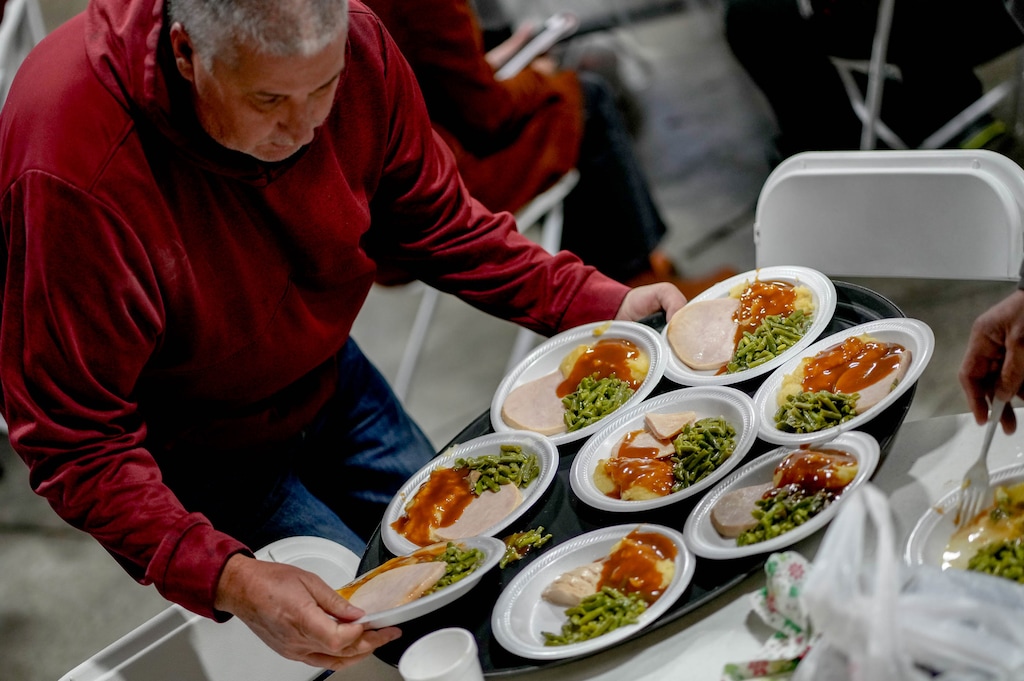 (Francisco Kjolseth  |  The Salt Lake Tribune) Volunteer Larry Reed serves Thanksgiving day meals at the Salt Lake Mission on Thursday, Nov. 23, 2023.