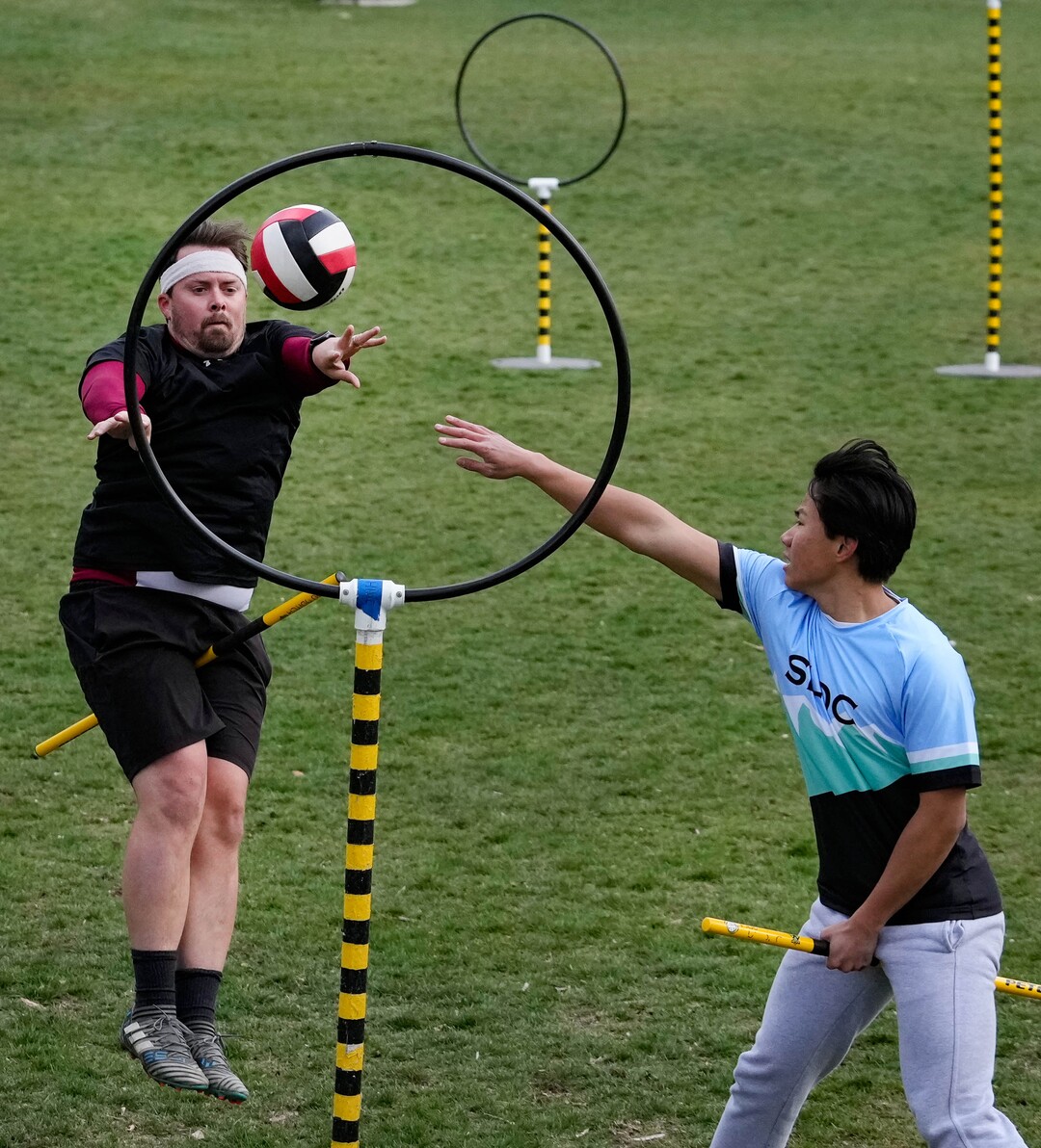 (Francisco Kjolseth | The Salt Lake Tribune) Matthew Williams scores as Michael Liou tries to block him from the hoop while playing Quidditch at Reservoir Park in Salt Lake City on Wednesday, April 13, 2022. The US Quidditch 2022 National Championships will be held in Salt Lake City on April 23-24. 