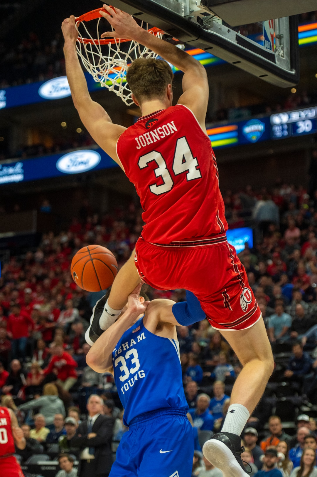(Rick Egan  |  The Salt Lake Tribune)   Utah Utes center Jayce Johnson (34) dunks the ball and takes out against the Brigham Young Cougars forward Dayton Nixon (33) on the play in basketball action in the Beehive Classic, between against the Brigham Young Cougars and Utah Utes, a the Vivint Smart Home Arena, Saturday December 8, 2018.