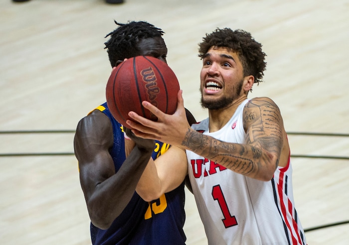 (Rick Egan | The Salt Lake Tribune) Utah Utes forward Timmy Allen (1) takes the ball to the basket as California Golden Bears forward Kuany Kuany (13) defends, in PAC12 Basketball action between the the Utah Utes and the California Golden Bears, on Wednesday, Jan. 16, 2021.