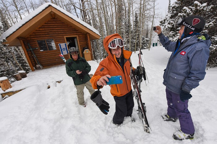 (Francisco Kjolseth | The Salt Lake Tribune) Brothers Perry Hoffman, center, of Chicago and Mark, at right, from San Diego, first time visitors to the "Ski Shul," at Deer Valley Resort, document the beautiful setting of the Jewish Sabbath service they had just attended at the Sunset Cabin.