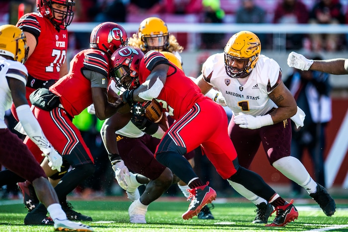 (Chris Detrick  |  The Salt Lake Tribune)  Utah Utes running back Zack Moss (2) is tackled by Arizona State Sun Devils linebacker Christian Sam (2) and Arizona State Sun Devils defensive lineman JoJo Wicker (1) during the game at Rice-Eccles Stadium Saturday, October 21, 2017.  Arizona State Sun Devils defeated Utah Utes 30-10.