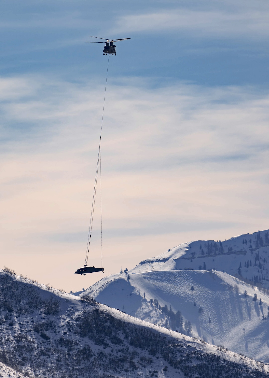 (Francisco Kjolseth | The Salt Lake Tribune) Recovery operations for two Utah Army National Guard UH-60 Black Hawk helicopters involved in a training accident in the Mineral Basin area last week are performed by a CH-47 Chinook helicopter and brought to the Heber Valley Airport on Wednesday, March 2, 2022.