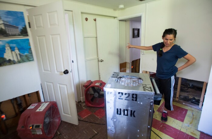 (Rick Egan  |  The Salt Lake Tribune)  Ana Holt  walks amount the fans, not that the carpet and everything has been removed from her basement. Nearly everything that was in the basement needs to be thrown away, after sewage water flooded the basement of her home 2100 South. Tuesday, August 1, 2017.