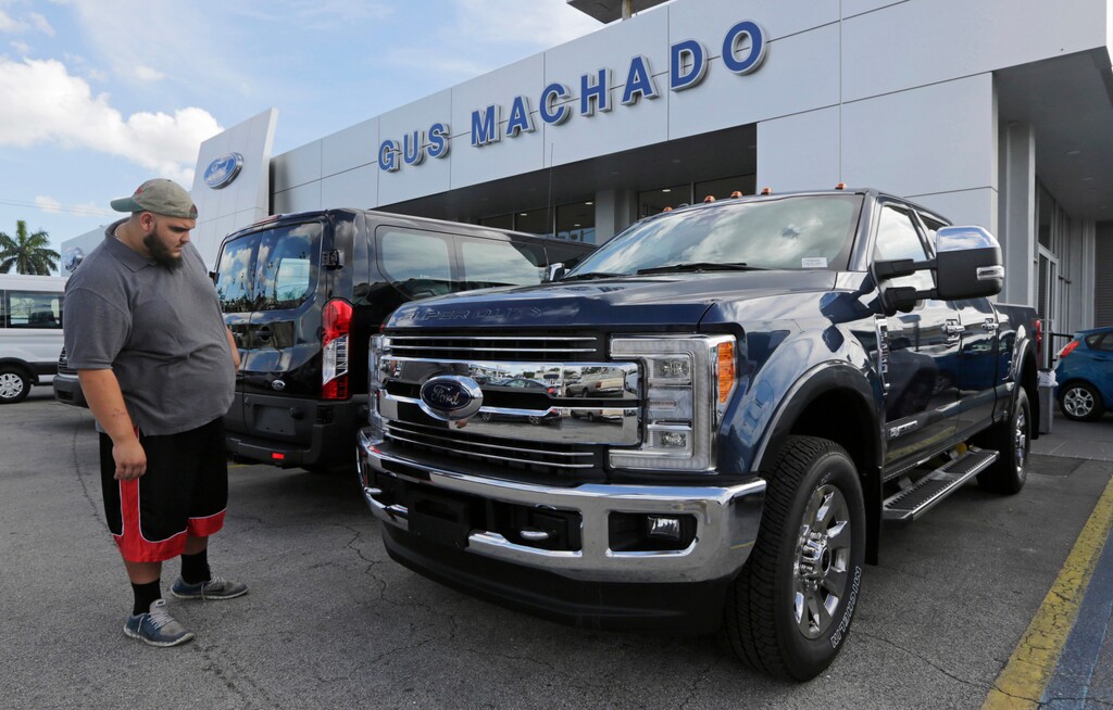 FILE - In this Tuesday, Jan. 17, 2017, file photo, a potential customer looks at a Ford F-250 Lariat FX4 at a Ford dealership, in Hialeah, Fla. Ford posted a big sales jump in October 2017 but Fiat Chrysler and General Motors reported declines as auto companies started to report numbers Wednesday, Nov. 1. The drop by two of the Detroit Three backs analysts’ expectations that September’s big gain in U.S. auto sales would fizzle in October. (AP Photo/Alan Diaz, File)