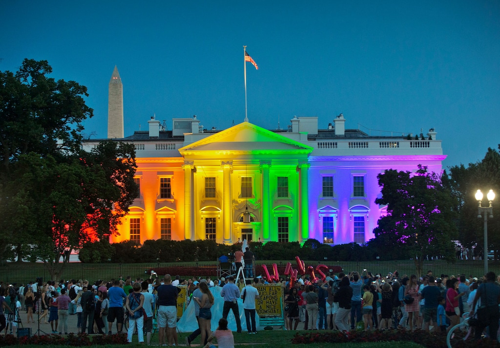 FILE - In this Friday, June 26, 2015 file photo, people gather in Lafayette Park to see the White House illuminated with rainbow colors in commemoration of the Supreme Court's ruling to legalize same-sex marriage in Washington. The Trump administration Friday, June 12, 2020, finalized a regulation that overturns Obama-era protections for transgender people against sex discrimination in health care. (AP Photo/Pablo Martinez Monsivais, File)
