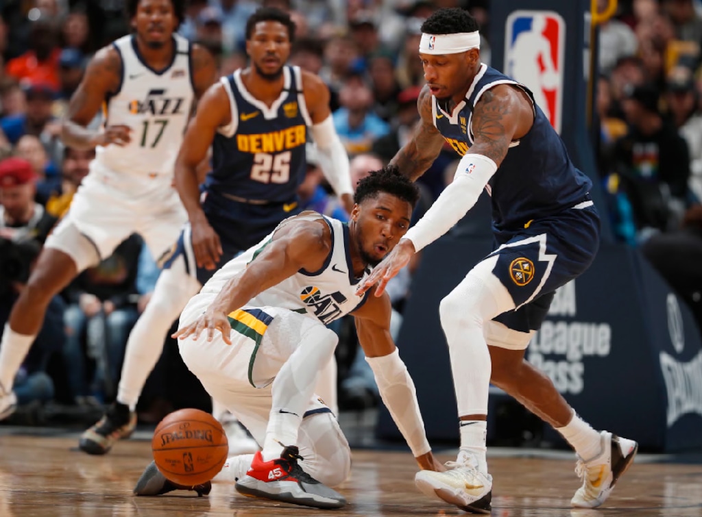 Utah Jazz guard Donovan Mitchell, left, reaches for the ball next to Denver Nuggets forward Torrey Craig during the first half of an NBA basketball game Thursday, Jan. 30, 2020, in Denver. (AP Photo/David Zalubowski)