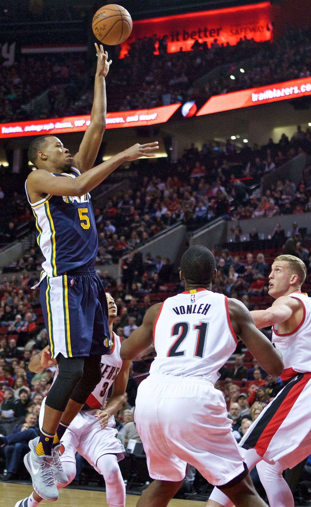Utah Jazz guard Rodney Hood, left, shoots over Portland Trail Blazers center Mason Plumlee, right, and forward Noah Vonleh, center, during the first half of an NBA basketball game in Portland, Ore., Wednesday, Jan. 13, 2016. (AP Photo/Craig Mitchelldyer)