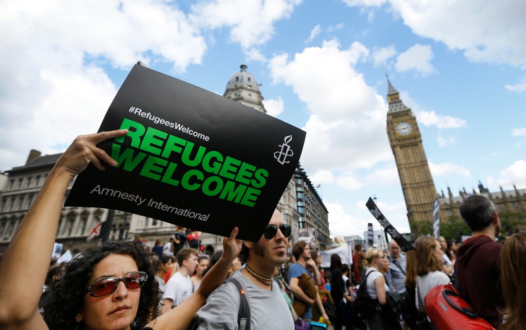 Demonstrators hold banners during a Solidarity with Refugees march from Marble Arch to Parliament in London, Saturday, Sept. 12, 2015. (AP Photo/Kirsty Wigglesworth)