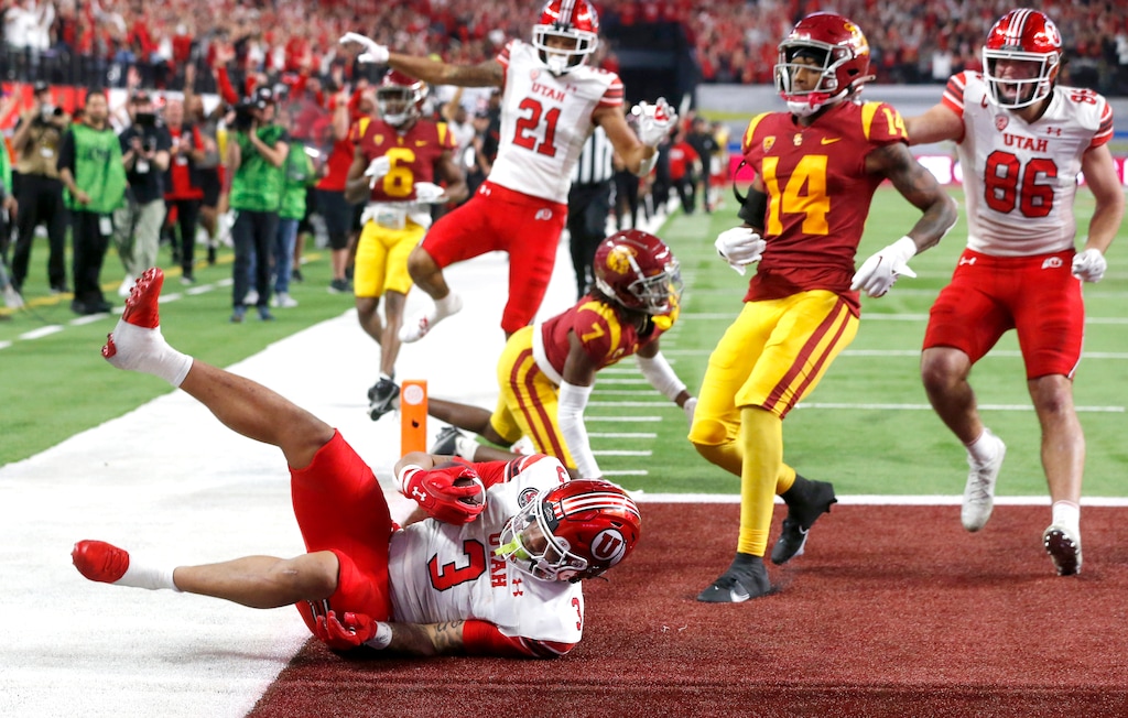 Utah running back Ja'Quinden Jackson (3) falls into the end zone for a touchdown, next to Southern California defensive backs Calen Bullock (7) and Jacobe Covington (14) during the second half of the Pac-12 Conference championship NCAA college football game Friday, Dec. 2, 2022, in Las Vegas. Utah wide receiver Solomon Enis (21) and tight end Dalton Kincaid (86) celebrate. (AP Photo/Steve Marcus)