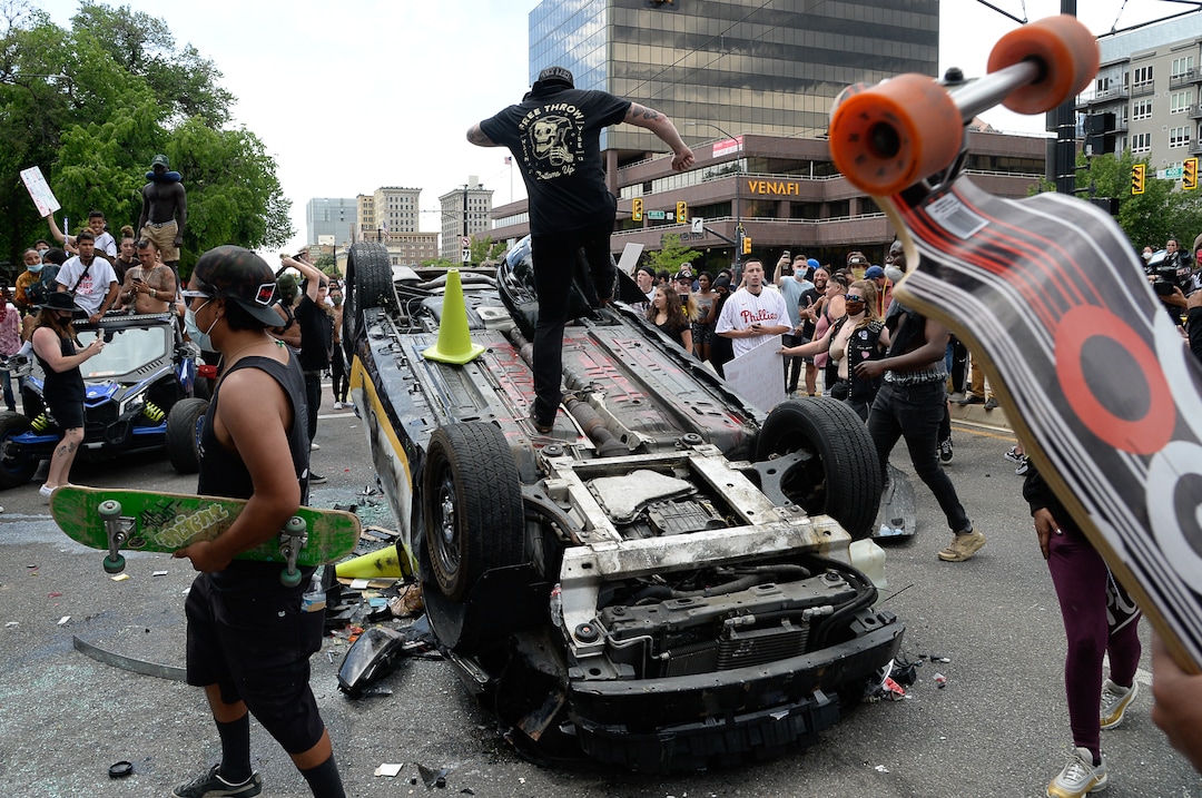 (Francisco Kjolseth  |  The Salt Lake Tribune) Protesters danced and jumped on an overturned police car in Salt Lake City on May 30, 2020