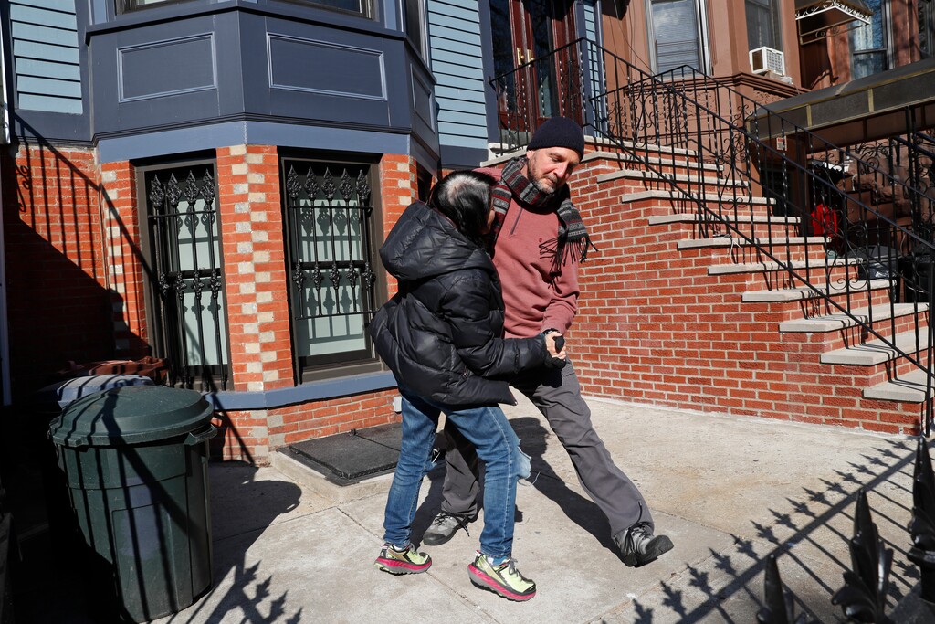 (Kathy Willens | AP file photo) In this Wednesday, April 15, 2020 photo, Tim Sozen, right, and his partner Madeline Chang dance on a small patch of concrete in front of their Brooklyn apartment during a stoop concert by accordionist Paul Stein, who plays from his stoop several townhouses away to lift neighbors' spirits while encouraging social distancing during the coronavirus outbreak in the Sunset Park neighborhood in New York. "We were inspired because the music is so wonderful. Music is so powerful. It's its own language," says Chang.