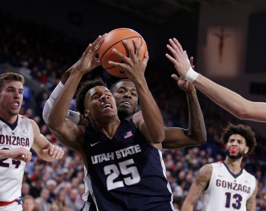 Utah State forward Dwayne Brown Jr. (25) grabs a rebound in front of teammate guard DeAngelo Isby during the first half of an NCAA college basketball game against Gonzaga in Spokane, Wash., Saturday, Nov. 18, 2017. (AP Photo/Young Kwak)