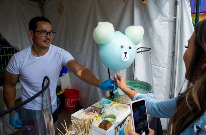 (Rick Egan  |  The Salt Lake Tribune)    
 Matt Kim from Seattle hands a cotton candy shaped like a bear to a customer as he works at the Sweet Art booth at the Utah State Fair Monday, Sept. 9, 2019.