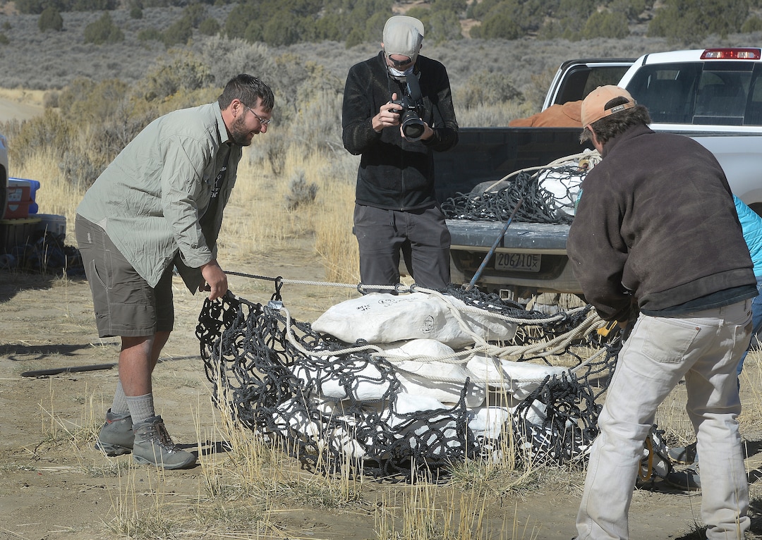 (Scott Sommerdorf   |  The Salt Lake Tribune)   
Tylor Birthisel, left, and Alan Titus, right work to unload one of the plaster-encased bundles of the fossilized Tyrannosaurus Rex skeleton found near Tropic, Utah, Sunday, October 15, 2017. The collected pieces of the animals' skeleton were airlifted to this site from the site where the skeleton was found in 2015 by Titus.