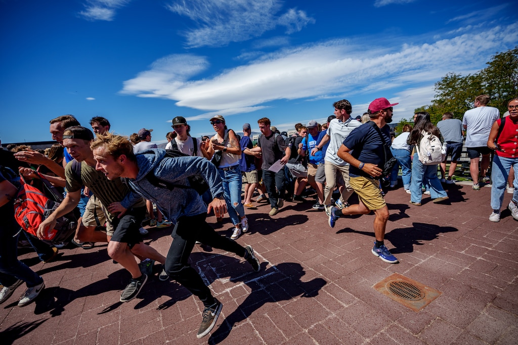 (Trent Nelson | The Salt Lake Tribune) Crowd members run after a gunshot was heard at Utah Valley University in Orem, Wednesday, Sept. 10, 2025. This is the first photo Tribune photographer Trent Nelson filed after the shooting.