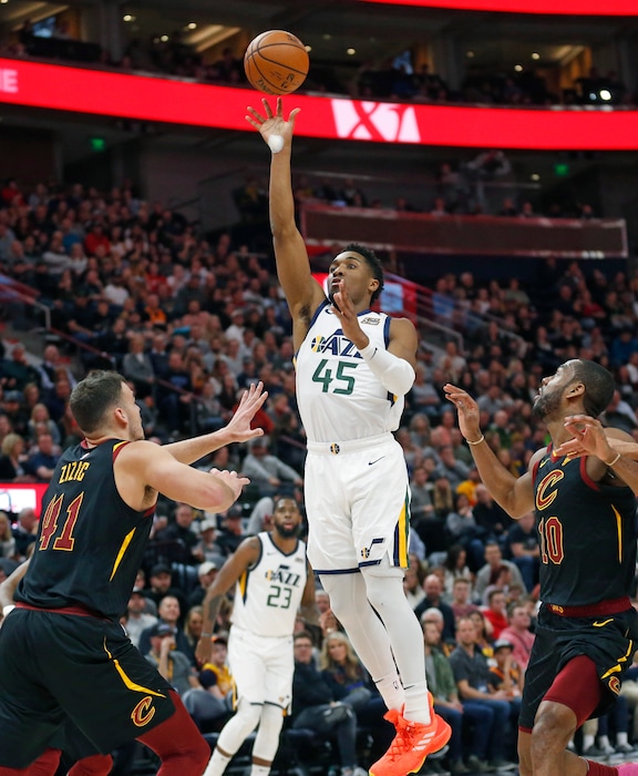Utah Jazz guard Donovan Mitchell (45) shoots as Cleveland Cavaliers' Ante Zizic (41) and Alec Burks (10) defend during the first half in an NBA basketball game Friday, Jan. 18, 2019, in Salt lake City. (AP Photo/Rick Bowmer)