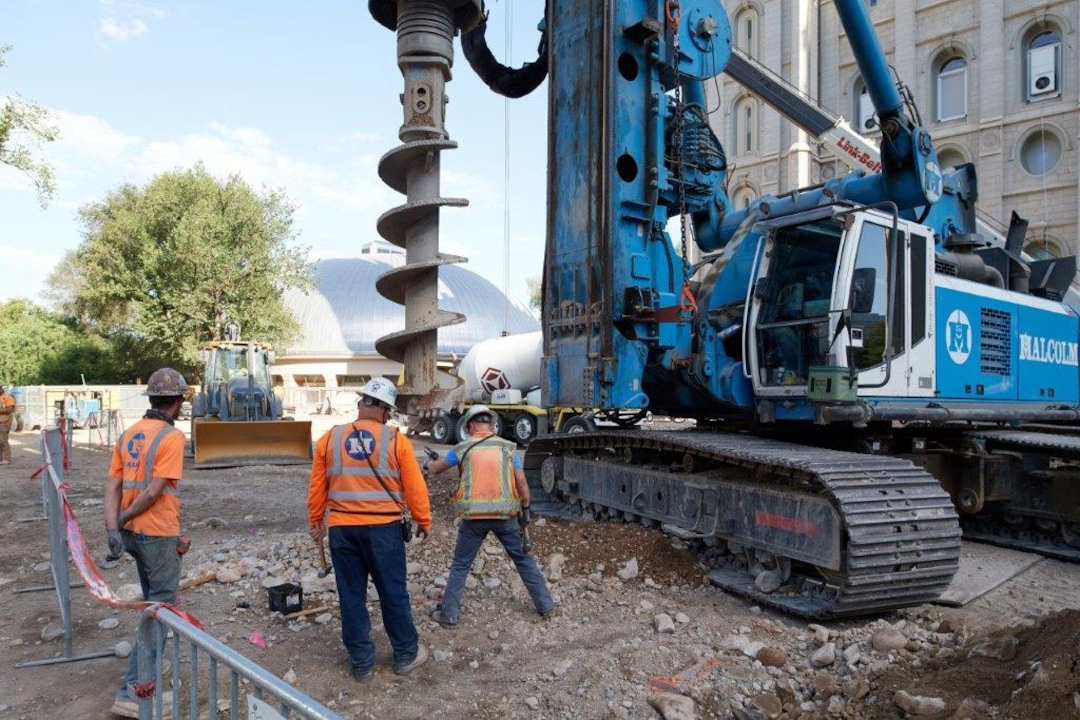 (Photo courtesy The Church of Jesus Christ of Latter-day Saints) In this June 2020 photo, an auger is drilling a hole with the help of segment casings. The 15-foot segment casings help create a hole up to 60 feet deep. A steel piling will be dropped into the hole and filled with concrete. The steel piles are part of a retaining wall that will line the temple property and will also be installed around the temple in preparation for excavating a 40-feet-deep hole as part of the seismic upgrade.