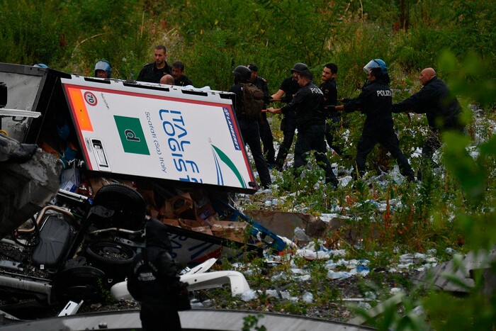 Rescues work among the debris of the collapsed Morandi highway bridge in Genoa, Tuesday, Aug. 14, 2018. Italian authorities say that about 10 vehicles were involved when the raised highway collapsed during a sudden and violent storm in the northern port city of Genoa, while private broadcaster Sky TG24 said the collapsed section was about 200-meter long (650 feet). (Luca Zennaro/ANSA via AP)