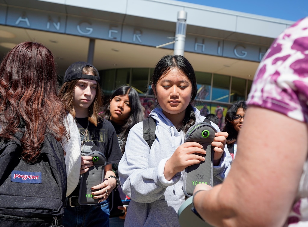 (Chris Samuels | The Salt Lake Tribune) Students leaving Granger High School in West Valley City unlock their cell phones after exiting the school’s doors, Monday, Aug. 26, 2024.