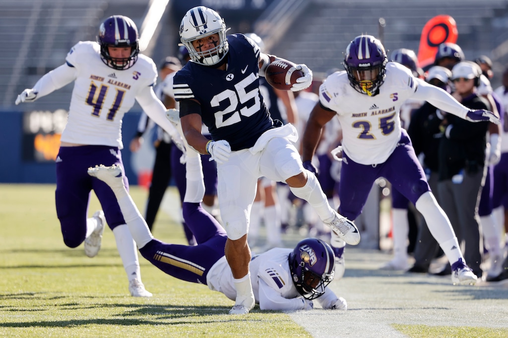 BYU running back Tyler Allgeier (25) runs the ball for a first down past North Alabama cornerback Will Singleton, bottom, defensive end Tyler Antkowiak (41) and linebacker Christon Taylor (25) in the second quarter during an NCAA college football game Saturday, Nov. 21, 2020, in Provo, Utah. (AP Photo/Jeff Swinger, Pool)